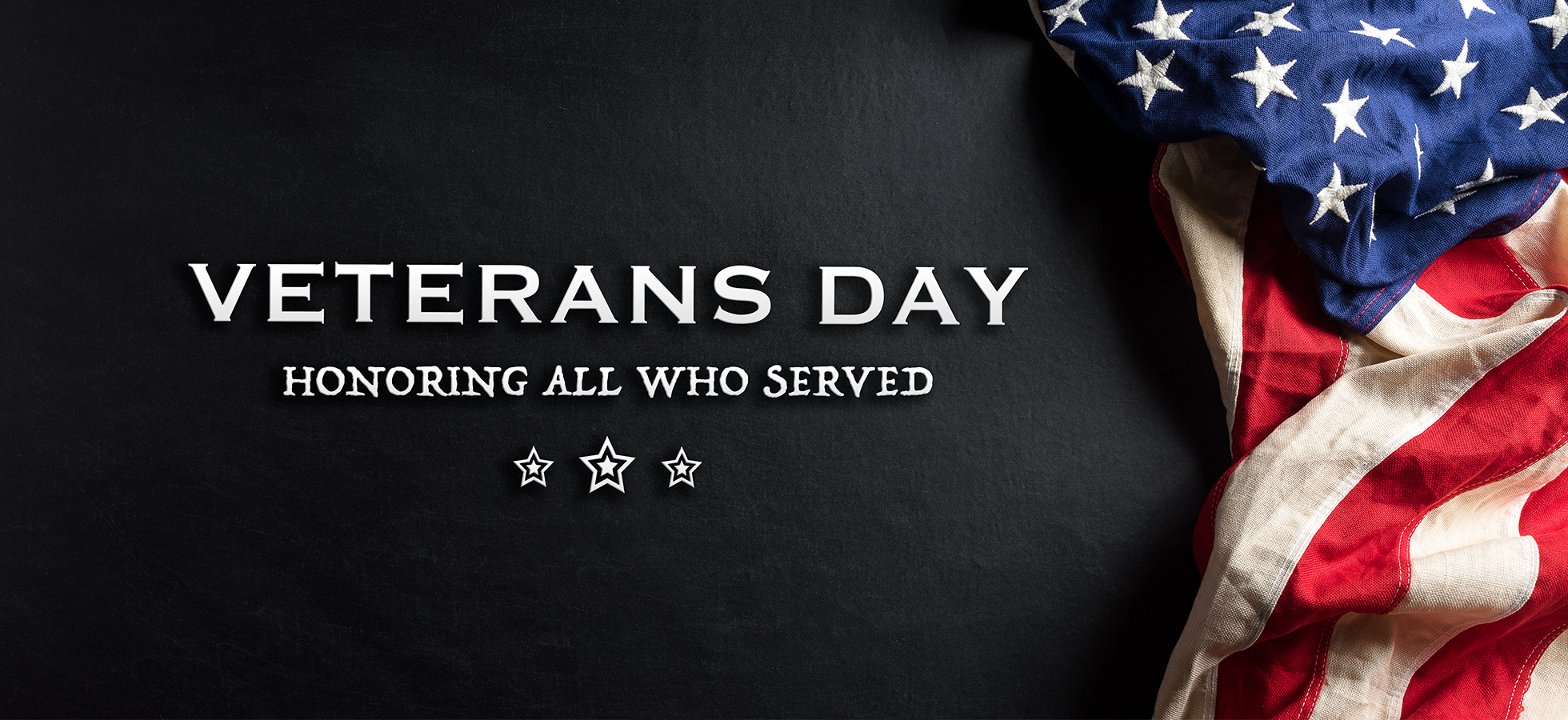 A graphic with an American flag to promote Assumption University's Veterans' Day observances.