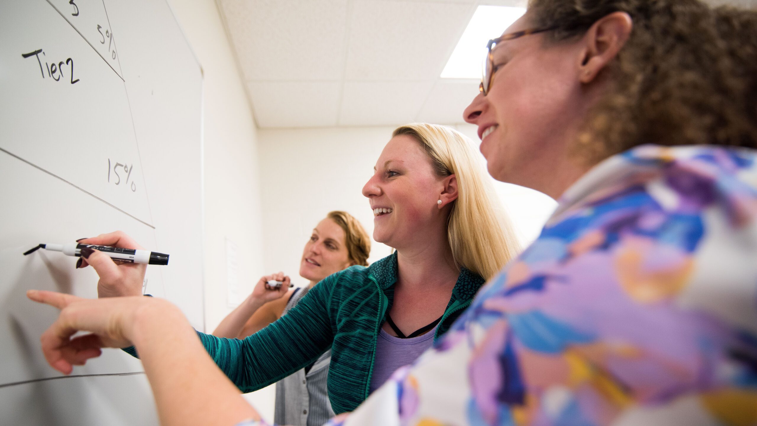 Faculty at Assumption University's School of Graduate Studies examine a whiteboard.