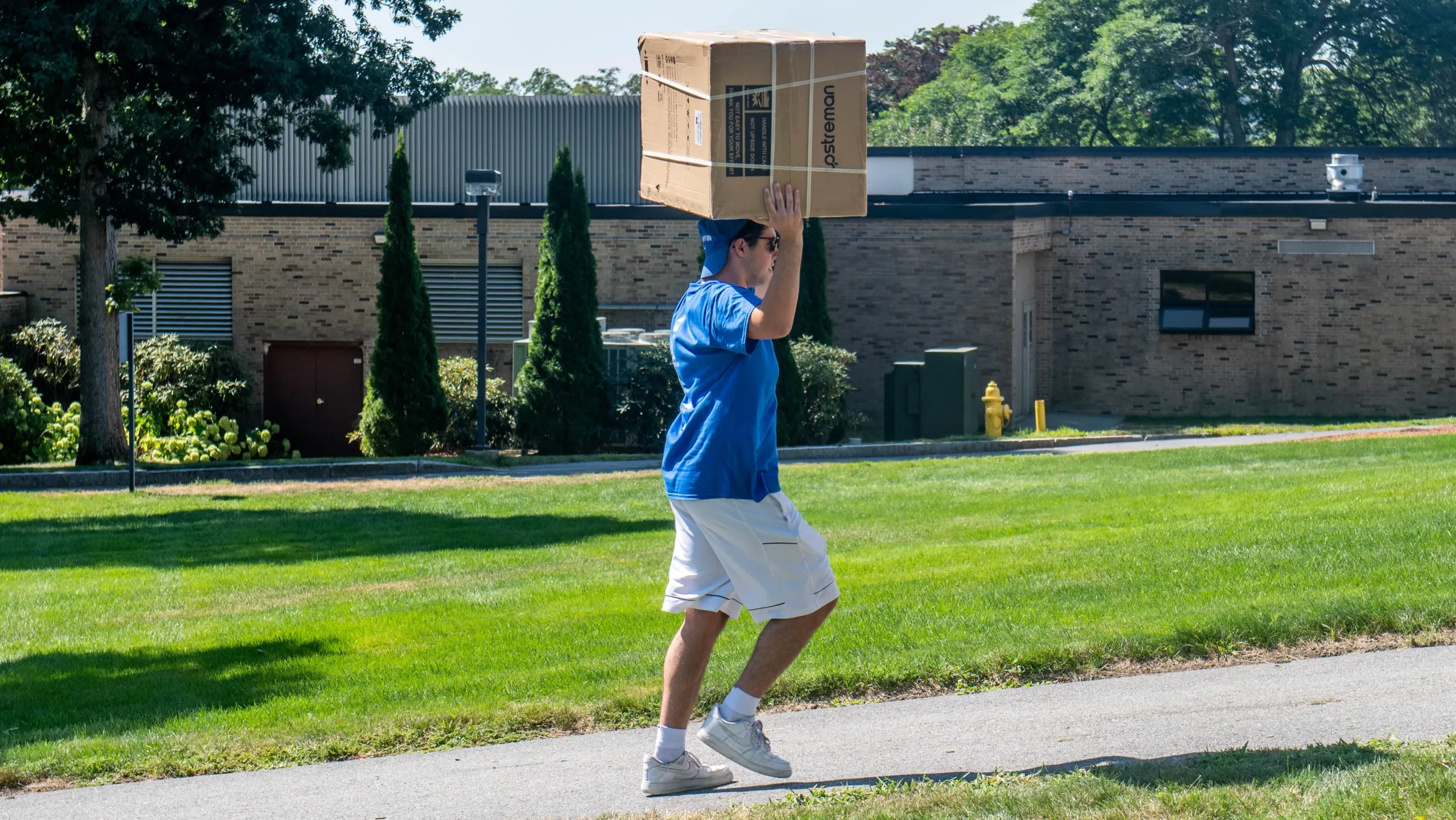 Assumption University student carrying a box into a dorm room