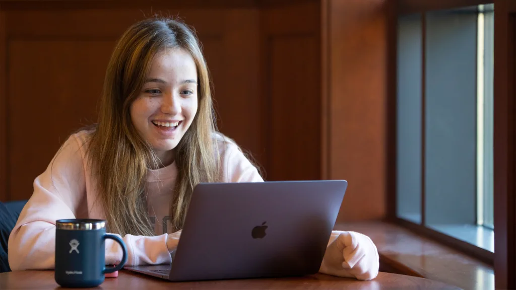 Assumption University student smiles while looking at her computer