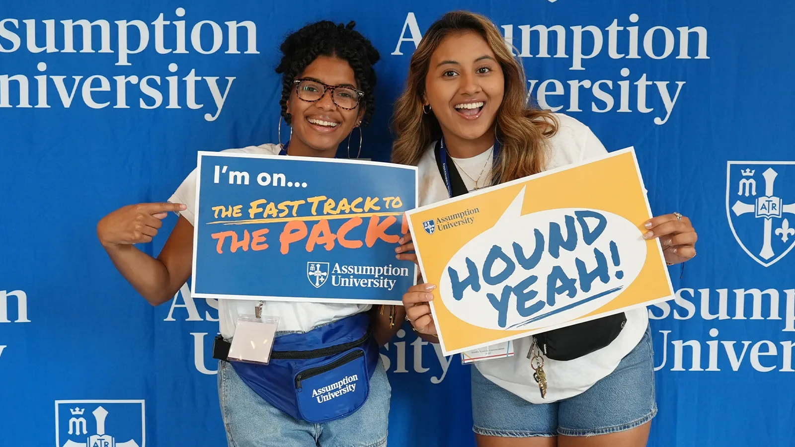 Assumption students holding up admissions and financial aid themed signs