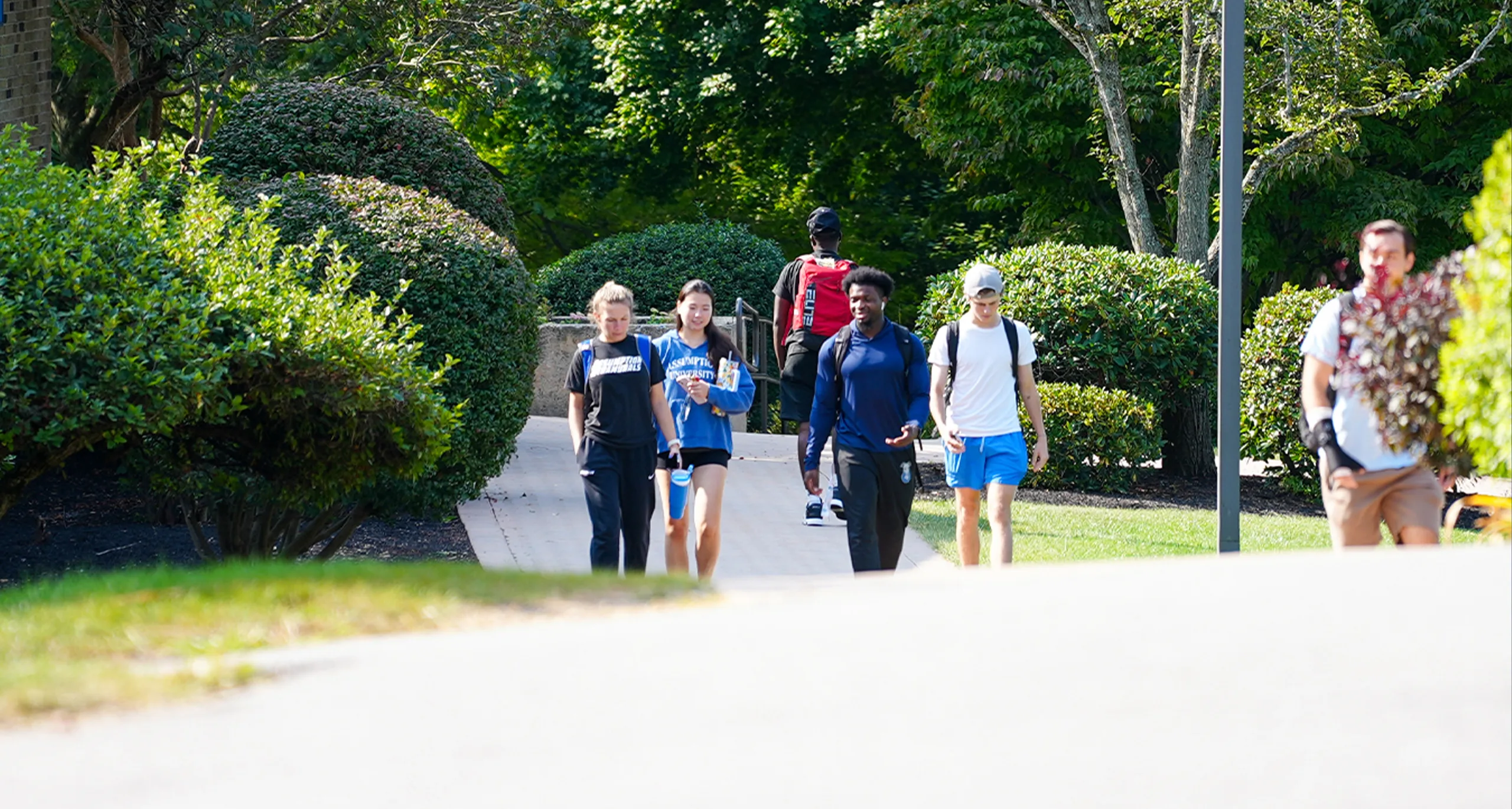 Assumption students walking together on walkway on campus